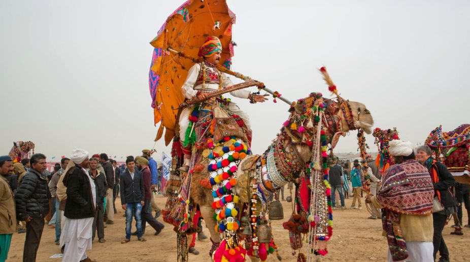 Jaisalmer, India - February 2, 2015: Camel driver riding on the rural show during the famous Desert Festival